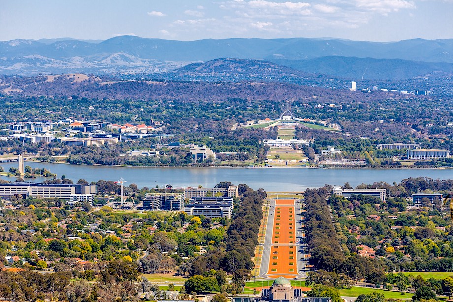 View of Canberra from Mount Ainslie lookout - ANZAC Parade, Parliament House and modern architecture with mountains in background. ACT, Australia
