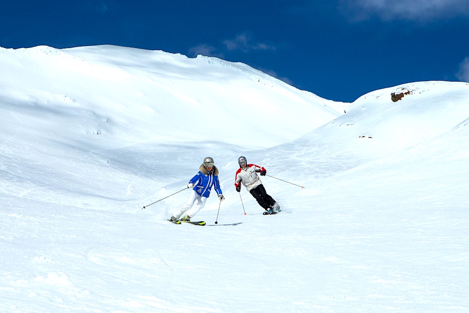 Dua pemain ski menuruni lereng salju di Gunung Ruapehu. 