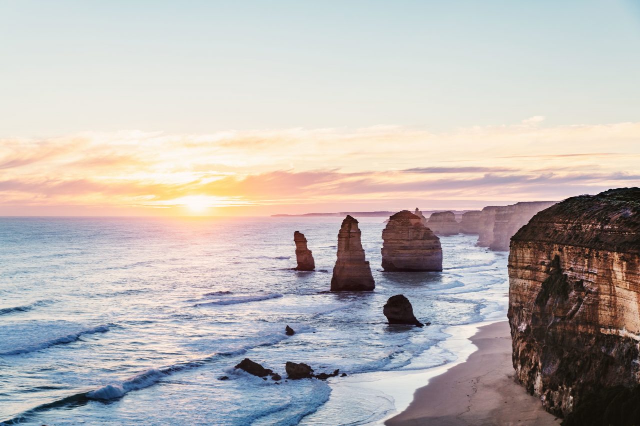 The Twelve Apostles at the beginning of sunset with wispy clouds and blue water
