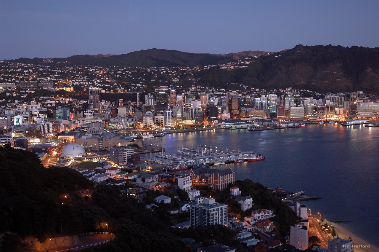 Wellington Harbour at night time. The city is all lit up with the water on the side