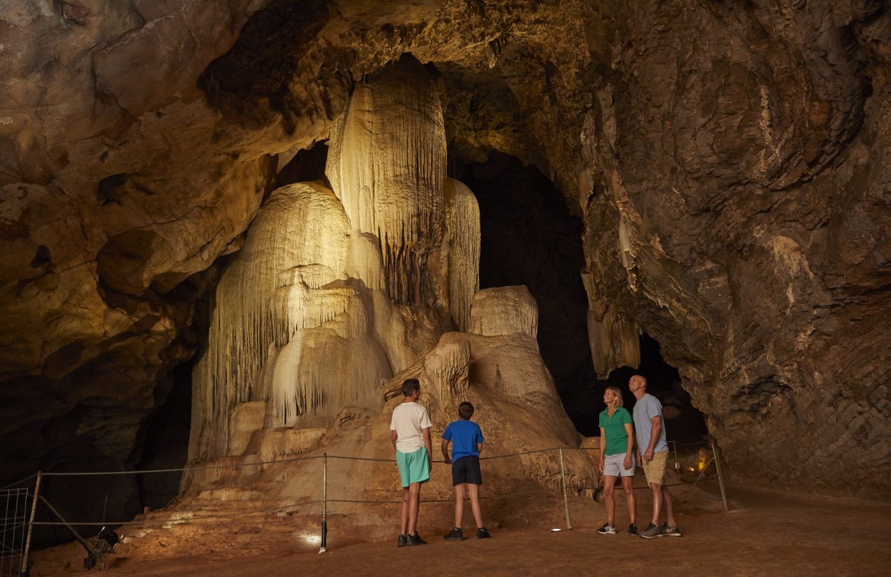 image of a family of 4 looking inside a cave and phosphate mine.