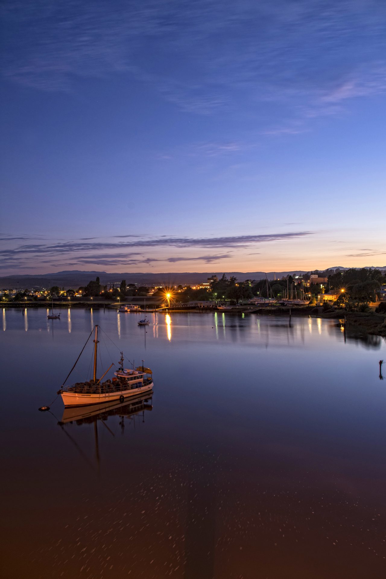 View of Launceston City at night time. a small boat in the forefront of the image.