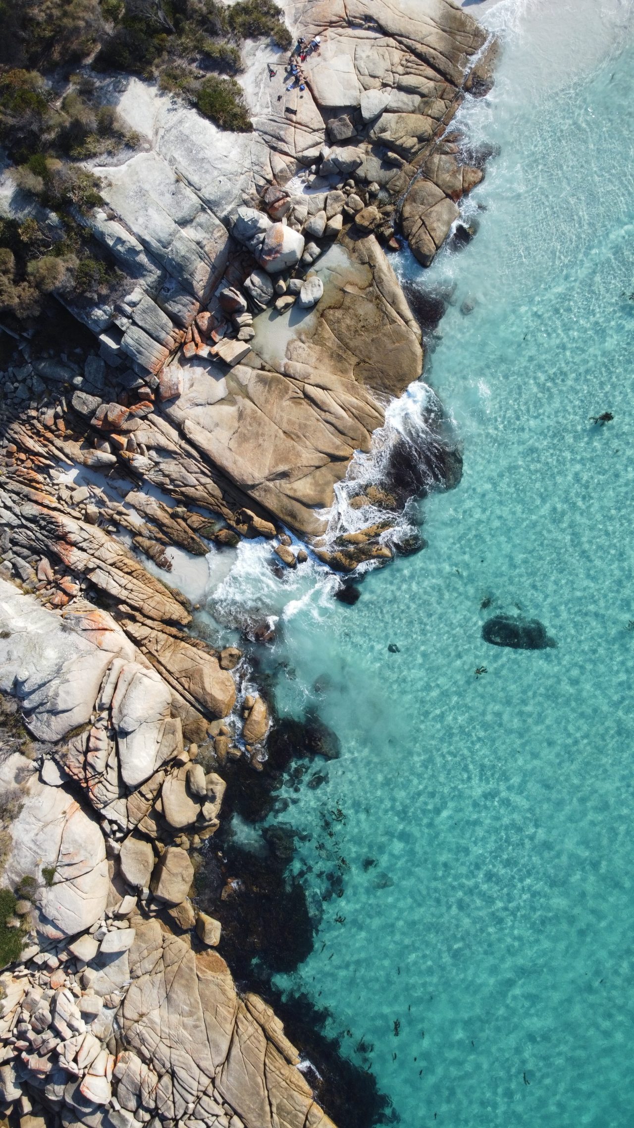 Aerial view of a bay with rocky scenes that meet the clear blue waters
