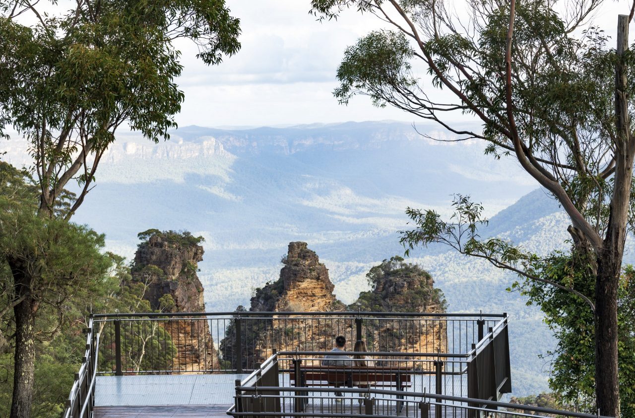 Couple enjoying the scenic views across the Jamison Valley from Echo Point Lookout in the Blue Mountains.